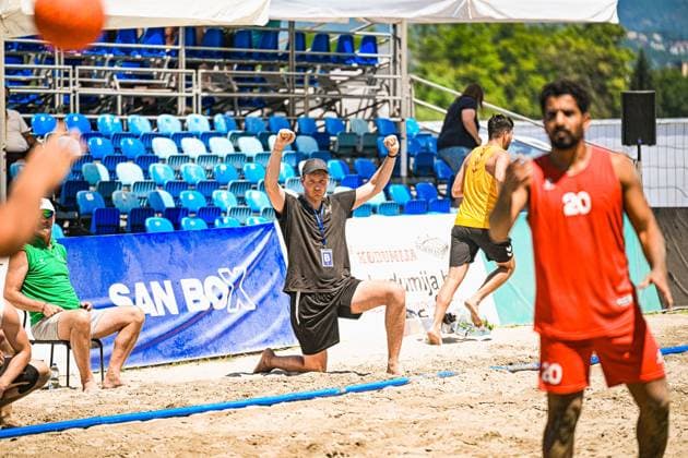 Oliver Middell ( 20; Deutschland Beachhandball Nationalmannschaft) steht im Vordergrund, während ein Betreuer Trainer in schwarzem Shirt mit geballten Fäusten auf dem Sand kniet und jubelt. Im Hintergrund sind weitere Spieler in gelb-roten Trikots sowie blaue Zuschauerränge zu sehen. IHF Beach Handball World Championship, WM, Weltmeisterschaft 2026, 23.06.2026, Zagreb, Jarun See *** Oliver Middell 20: The German national beach handball team is in the foreground, while a coach in a black shirt kneels on the sand with clenched fists, cheering. In the background, other players in yellow and red jerseys can be seen, as well as blue spectator stands. IHF Beach Handball World Championship 2026, June 23, 2026, Zagreb, Lake Jarun Copyright: xspeedshotx xDorianfrickx