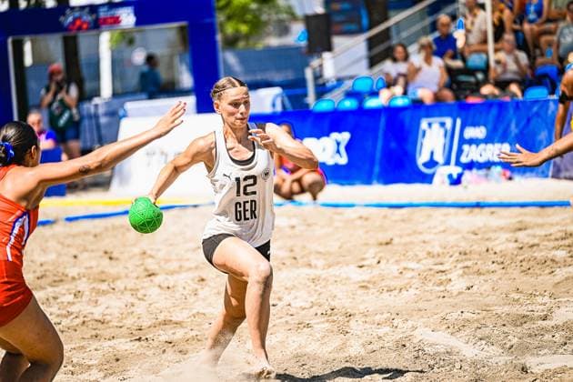 Dilayla Alarslan ( 12; Deutsche Frauen Beachhandball Nationalmannschaft) läuft mit dem Ball am Sandplatz am Jarun See in Zagreb und wird von einer Gegenspielerin der USA woman gedrängt. Die Szene zeigt eine intensive Angriffsaktion im Sonnenlicht. IHF Beach Handball World Championship, WM, Weltmeisterschaft 2026, 23.06.2026, Zagreb, Jarun See *** Dilayla Alarslan, a member of the German women’s beach handball national team, runs with the ball on the sand court at Lake Jarun in Zagreb and is pushed by an opponent from the U.S. women’s team. The scene shows an intense offensive play in the sunlight at the 2026 IHF Beach Handball World Championship, June 23, 2026, Zagreb, Lake Jarun Copyright: xspeedshotx xDorianfrickx