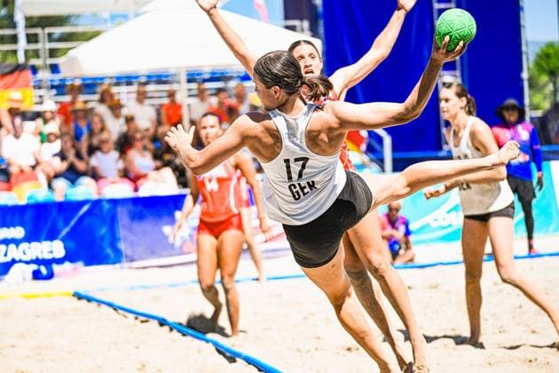 Lena Klingler ( 17; Deutsche Frauen Beachhandball Nationalmannschaft) springt mit gestrecktem Bein zum Wurf und hält den Ball hoch in der Luft. Im Hintergrund sind Spielerinnen der USA sowie Zuschauer am Jarun See in Zagreb zu sehen. IHF Beach Handball World Championship, WM, Weltmeisterschaft 2026, 23.06.2026, Zagreb, Jarun See *** Lena Klingler, a member of the German women’s beach handball national team, jumps with her leg extended to take a shot and keeps the ball high in the air. In the background, players from the U.S. and spectators can be seen at Lake Jarun in Zagreb. IHF Beach Handball World Championship 2026, June 23, 2026, Zagreb, Lake Jarun Copyright: xspeedshotx xDorianfrickx