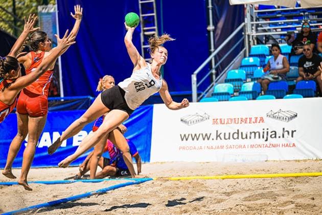 Emma Pilz ( 9; Deutsche Frauen Beachhandball Nationalmannschaft) zieht in der Luft zum Wurf ab, während zwei Spielerinnen der USA woman die Arme hochreißen. Die Szene findet im Sand am Jarun See in Zagreb statt. IHF Beach Handball World Championship, WM, Weltmeisterschaft 2026, 23.06.2026, Zagreb, Jarun See *** Emma Pilz: A player from the German women’s national beach handball team takes a shot while two players from the U.S. women’s team raise their arms. The scene takes place on the sand at Lake Jarun in Zagreb during the 2026 IHF Beach Handball World Championship, June 23, 2026, Zagreb, Lake Jarun Copyright: xspeedshotx xDorianfrickx