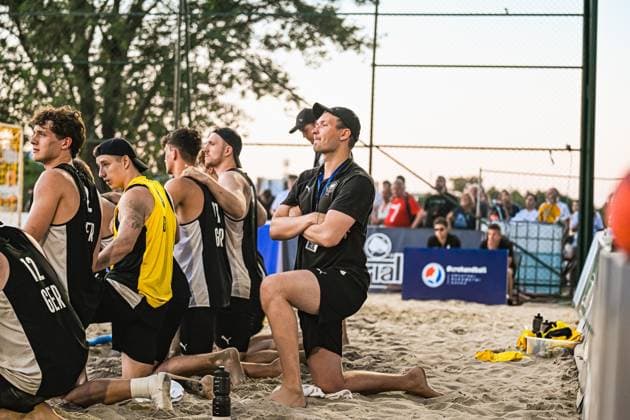 Mehrere Spieler der deutschen Beachhandball-Nationalmannschaft knien im Sand und verfolgen konzentriert das Spielgeschehen, darunter ZEYEN Tobias ( 12; Deutschland Beachhandball Nationalmanschaft) und KRAUTH Tim ( 17; Deutschland Beachhandball Nationalmanschaft). Ein Betreuer in schwarzem Shirt beobachtet mit verschränkten Armen das Spiel, im Hintergrund sind Zuschauer und ein Pepsi-Werbebanner sichtbar. IHF Beach Handball World Championship, WM, Weltmeisterschaft 2026, 23.06.2026, Zagreb, Jarun See *** Several players from the German national beach handball team are kneeling in the sand, intently watching the game, including Tobias ZEYEN (No. 12), Germany’s national beach handball team, and Tim KRAUTH (No. 17), Germany’s national beach handball team. A coach in a black shirt watches the game with his arms crossed, with spectators and a Pepsi advertising banner visible in the background. IHF Beach Handball World Championship 2026, June 23, 2026, Zagreb, Lake Jarun Copyright: xspeedshotx xDorianfrickx