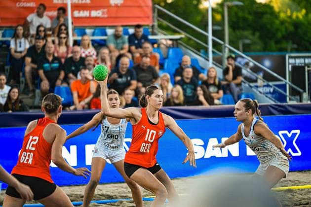 Isabel Kattner ( 10; Deutsche Frauen Beachhandball Nationalmannschaft) hält den Ball hoch und bereitet einen Wurf vor, während sie von kroatischen Gegenspielerinnen unter Druck gesetzt wird. Links im Bild ist Dilayla Alarslan ( 12; Deutsche Frauen Beachhandball Nationalmannschaft) zu sehen, im Hintergrund verfolgen zahlreiche Zuschauer das Spiel am Jarun See in Zagreb. IHF Beach Handball World Championship, WM, Weltmeisterschaft 2026, 23.06.2026, Zagreb, Jarun See *** Isabel Kattner (No. 10) of the German Women’s Beach Handball National Team keeps the ball in the air and prepares a shot while under pressure from Croatian opponents. On the left side of the picture is Dilayla Alarslan (No. 12) of the German Women’s Beach Handball National Team, and in the background, numerous spectators watch the game at Lake Jarun in Zagreb. IHF Beach Handball World Championship 2026, June 23, 2026, Zagreb, Lake Jarun Copyright: xspeedshotx xDorianfrickx
