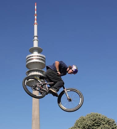 26.06.2026, MASH Munich 2026, Olympia Park Muenchen, im Bild: Moutainbiker bei MASH 2026 vor der Olympiaturm Muenchen *** June 26, 2026, MASH Munich 2026, Olympic Park, Munich; pictured: mountain bikers at MASH 2026 in front of the Olympic Tower in Munich