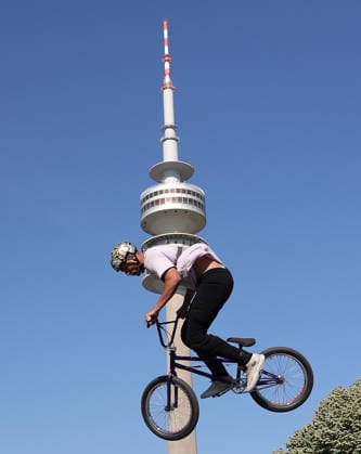 26.06.2026, MASH Munich 2026, Olympia Park Muenchen, im Bild: BMX Biker bei MASH 2026 vor der Olympiaturm Muenchen *** June 26, 2026, MASH Munich 2026, Olympic Park, Munich; pictured: BMX riders at MASH 2026 in front of the Olympic Tower in Munich