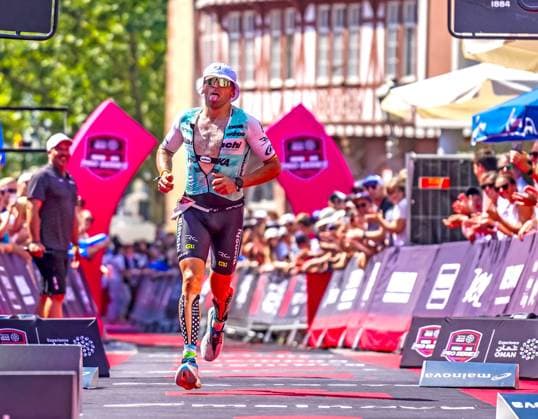 Benito Lopez auf Platz drei beim Ironman Frankfurt 2026 28.06.26: Der Profi-Triathlet Benito Lopez läuft mit geöffnetem Einteiler und weißem Sonnenhut sichtlich erschöpft, aber glücklich auf dem Römerberg ins Ziel. Er sichert sich den dritten Podiumsplatz (3. Platz) bei der Ironman Europameisterschaft European Championship, EM, Europameisterschaft 2026 in Frankfurt am Main. Frankfurt Hessen Deutschland *** Benito Lopez Takes Third Place at Ironman Frankfurt 2026, June 28, 2026. Professional triathlete Benito Lopez, wearing an open wetsuit and a white sun hat, runs across the finish line on the Römerberg, visibly exhausted, but happy, as he crosses the finish line on the Römerberg. He secures third place on the podium at the 2026 Ironman European Championship in Frankfurt am Main, Frankfurt, Hesse, Germany JRT01003