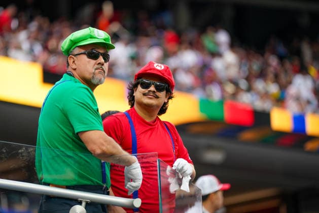USA: Fußball FIFA World Cup, WM, Weltmeisterschaft, Fussball 2026, Sechzehntelfinale, Round of 32, Südafrika vs Kanada, South Africa vs Canada, SoFi Stadium (Inglewood, Los Angeles County, Kalifornien): Porträt, zwei Fußballfans, Fankostüm, Mario, Luigi, Super Mario Bros., Cosplay, Verkleidung, Sonnenbrillen, Schnurrbart, Mütze, Handschuhe, Hosenträger, Zuschauer, Tribüne, Stadion, Fankultur, Fußballbegeisterung, Stimmung, Sportevent, Unterhaltung, Publikum, kreative Fanbekleidung, Freizeit, Medienmotiv, Nahaufnahme, Farbkontrast, Eventatmosphäre. *** USA Soccer FIFA World Cup 2026, Round of 32, South Africa vs. Canada, SoFi Stadium, Inglewood, Los Angeles County, California; portrait of two soccer fans in fan costumes, Mario, Luigi, Super Mario Bros., cosplay, costume, sunglasses, mustache, cap, gloves, suspenders, spectators, bleachers, stadium, fan culture, soccer enthusiasm, atmosphere, sporting event, entertainment, audience, creative fan attire, leisure, media image, close-up, color contrast, event atmosphere Copyright: xJOERANxSTEINSIEKx