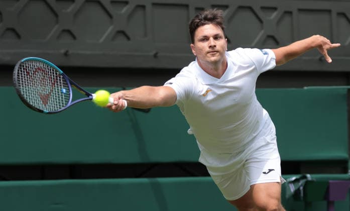 Serbian Miomir Kecmanovic plays a forehand in his match against Italy s Jannik Sinner on day one of the 2026 Wimbledon Championships in London on Monday, June 29, 2026.  LON2026062914 HUGOxPHILPOTT