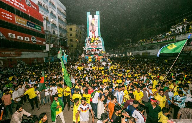 June 30, 2026, Munshiganj, Bangladesh: Thousands of Brazilian football supporters flood the Supermarket Chottor, as Brazil secured a 2-1 victory over Japan in the FIFA World Cup, WM, Weltmeisterschaft, Fussball 2026 group stage. Despite heavy rain, the crowd - draped in yellow jerseys and waving green-and-gold flags - packed every inch of the square, climbing monument structures and rooftops to catch a glimpse of the giant screen. Dhaka Bangladesh - ZUMAa259 0860352476st Copyright: xRayhanxAhmedx
