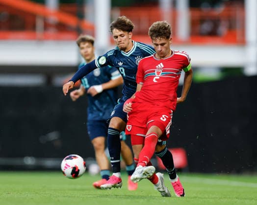 Wrexham, Wales, 1st July 2026. Brayden Clarke of Wales passes the ball while under pressure from Otto Stange of Germany during the Wales U19 vs Germany U19 UEFA European U19 Championship match at The Racecourse, Wrexham. Picture credit should read: Cody Froggatt Sportimage EDITORIAL USE ONLY. No use with unauthorised audio, video, data, fixture lists, club league logos or live services. Online in-match use limited to 120 images, no video emulation. No use in betting, games or single club league player publications. SPI_028_CF_WALES_U19_V_GERMANY_U19 SPI-4854-0028