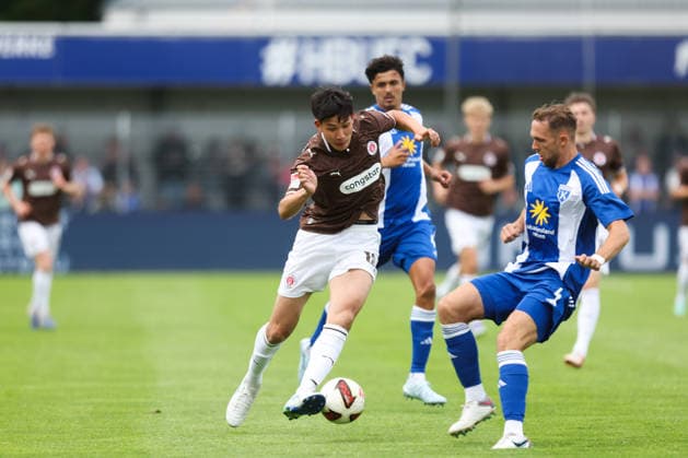 04.07.2026, Fussball, Herren, Regionalliga Nord, Testspiel, BSV Kickers Emden - FC St Pauli Taichi Hara (FC St Pauli) im Zweikampf mit Fabian Herbst (blau 4 BSV Kickers Emden) *** July 4, 2026, Soccer, Men s, Regionalliga Nord, Friendly Match, BSV Kickers Emden vs. FC St. Pauli, Taichi Hara (FC St. Pauli) in a tackle with Fabian Herbst (blue jersey 4, BSV Kickers Emden)