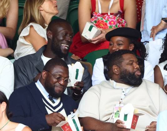 Stormzy and Little Simz eating strawberries watching the action on Centre Court Wimbledon Tennis Championships, Day 7, The All England Lawn Tennis and Croquet Club, London, UK - 05 Jul 2026London The All England Lawn Tennis and United Kingdom  Copyright: xKieranxMcManus Shutterstockx 16976813bz