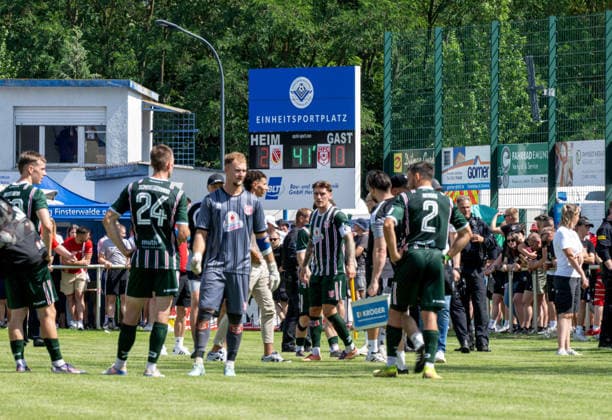 Fußball, Herren, Testspiel, Saison 2026 2027, Hallescher FC - FC Energie Cottbus in Finsterwalde, nach einer rassistischen Beleidigung ausgehend von einem Fan des HFC wurde das Spiel Mitte der zweiten Halbzeit abgebrochen, im Bild Anzeigetafel mit Zwischenstand, davor Spieler von Halle, 11.07. 2026, *** Soccer, Men s, Friendly Match, 2026–2027 Season, Hallescher FC vs. FC Energie Cottbus in Finsterwalde; following a racist slur from an HFC fan, the game was called off midway through the second half; pictured is the scoreboard showing the score at that point, with Halle players in the foreground, July 11, 2026, Copyright: xSebastianxRäppold MatthiasxKochx