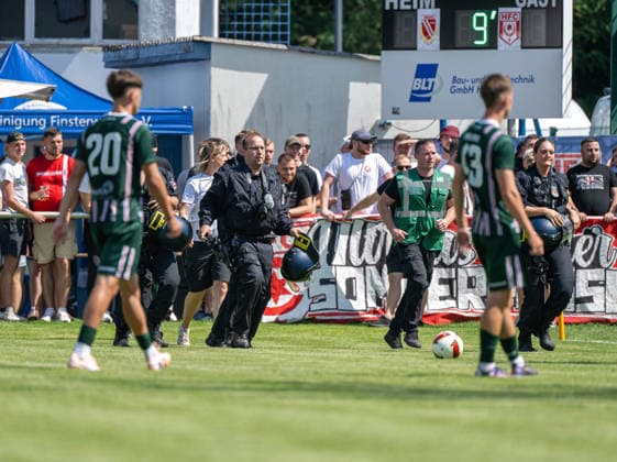 Fußball, Herren, Testspiel, Saison 2026 2027, Hallescher FC - FC Energie Cottbus in Finsterwalde, nach einer rassistischen Beleidigung ausgehend von einem Fan des HFC wurde das Spiel Mitte der zweiten Halbzeit abgebrochen, im Bild: Polizisten betreten den Rasen, 11.07. 2026, *** Soccer, Men s, Friendly Match, 2026–2027 Season, Hallescher FC vs. FC Energie Cottbus in Finsterwalde; following a racist slur from an HFC fan, the game was called off midway through the second half; pictured: police officers entering the field, July 11, 2026, Copyright: xSebastianxRäppold MatthiasxKochx