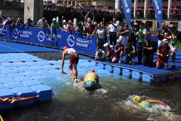 Athleten beim Schwimmen in der Binnenalster während des Triathlons. Zahlreiche Zuschauer und Fotografen säumen die Strecke entlang der Hamburg-Wasser-Absperrungen. Triathlon-Schwimmstrecke an der Binnenalster in Hamburg *** Athletes swimming in the Binnenalster during the triathlon. Numerous spectators and photographers line the course along the Hamburg Wasser barriers. Triathlon swim course on the Binnenalster in Hamburg Copyright: xspeedshotx xSarahxWolfx