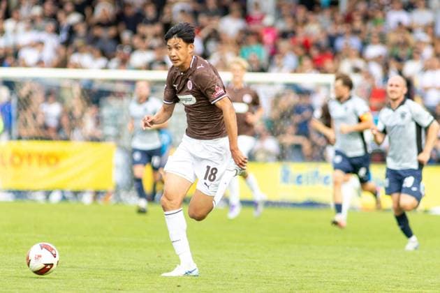 Taichi Hara ( 18; FC St. Pauli) sprintet im Karl-Liebknecht-Stadion Potsdam auf den Ball zu und setzt sich dabei von der Abwehr des SV Babelsberg 03 ab. Im Hintergrund verfolgen mehrere Babelsberg-Spieler die Aktion vor voll besetzten Rängen. Taichi Hara ( 18; FC St. Pauli) im Laufduell am Ball *** Taichi Hara (No. 18, FC St. Pauli) sprints toward the ball at the Karl Liebknecht Stadium in Potsdam, breaking away from the SV Babelsberg 03 defense. In the background, several Babelsberg players watch the action unfold in front of a packed crowd. Taichi Hara (No. 18, FC St. Pauli) is in a footrace for the ball. Copyright: xspeedshotx xAndreasxTolksdorfx