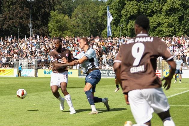 Ardahan Yilmaz ( 26; SV Babelsberg 03) kämpft im Zweikampf gegen einen Spieler von FC St. Pauli, während ein weiterer St.-Pauli-Spieler mit der Rückennummer 9 (CEESAY) die Szene beobachtet. Im Hintergrund verfolgen zahlreiche Zuschauer das Spiel im Karl-Liebknecht-Stadion in Potsdam. Ardahan Yilmaz ( 26; SV Babelsberg 03) im Zweikampf gegen FC St. Pauli *** Ardahan Yilmaz (26) of SV Babelsberg 03 battles for the ball against an FC St. Pauli player, while another St. Pauli player, number 9 CEESAY, watches the action. In the background, numerous spectators watch the game at Karl Liebknecht Stadium in Potsdam. Ardahan Yilmaz, number 26 for SV Babelsberg 03, battles for the ball against FC St. Pauli. Copyright: xAndreasxTolksdorfx