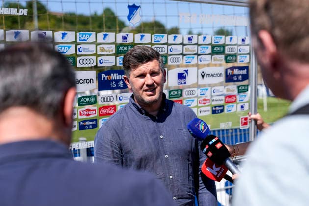 Andreas Schicker (Geschäftsführer Hoffenheim), mit Mikrofon beim Interview, TV, Fernsehen, Einzelbild, Einzelfoto, Aktion, Action, 12.07.2026, Zuzenhausen (Deutschland), Fussball, Bundesliga, Trainingsauftakt TSG 1899 Hoffenheim, DFB DFL REGULATIONS PROHIBIT ANY USE OF PHOTOGRAPHS AS IMAGE SEQUENCES AND OR QUASI-VIDEO. *** Andreas Schicker, Managing Director of Sports, Hoffenheim, holding a microphone during an interview, TV, television, still image, single photo, action, July 12, 2026, Zuzenhausen, Germany, soccer, Bundesliga, start of training for TSG 1899 Hoffenheim; DFB and DFL regulations prohibit any use of photographs as image sequences and or quasi-video xozx