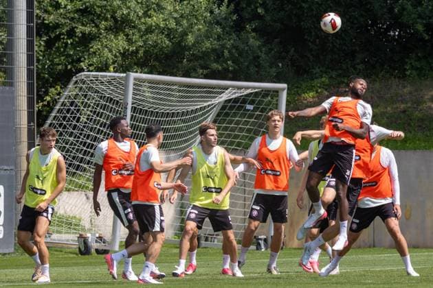 Im Trainingszentrum des FC St. Pauli in Hamburg liefern sich mehrere Spieler ein intensives Kopfballduell vor dem Tor. Ein Spieler in orangem Leibchen springt hoch und köpft den Ball, während seine Mitspieler in gelben und orangenen Leibchen die Szene beobachten. Standard Übungen beim FC St. Pauli *** At FC St. Pauli s training center in Hamburg, several players are engaged in an intense header battle in front of the goal. A player in an orange jersey jumps up and heads the ball, while his teammates in yellow and orange jerseys watch the action. Standard drills at FC St. Pauli Copyright: xAndreasxTolksdorfx