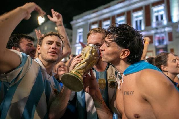 July 16, 2026, Madrid, Madrid, Spain: Argentine fans kiss a trophy resembling the FIFA World Cup, WM, Weltmeisterschaft, Fussball trophy..Argentine football fans celebrate their team s qualification for the 2026 FIFA World Cup final in Madrid s Puerta del Sol square after defeating England 2-1 in the semi-final...Argentina will face Spain in New York on Sunday, July 19. Argentine Fans Celebrate In Madrid Their Advancement To The 2026 World Cup Final.  - ZUMAs197 0861766146st Copyright: xSOPAxImagesx