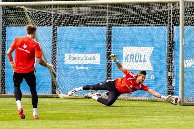 Ein Hamburger SV-Torwart hecht?? im Training mit vollem Körpereinsatz zur Seite und hält den Ball mit einer Hand. Im Hintergrund beobachtet ein weiterer Torhüter die Übungseinheit vor dem Tor. HSV-Torwart mit spektakulärer Flugparade im Training *** A Hamburg SV goalkeeper dives sideways with all his might during practice and catches the ball with one hand. In the background, another goalkeeper watches the practice session in front of the goal. HSV goalkeeper makes a spectacular diving save during practice Copyright: xspeedshotx xAndreasxTolksdorfx