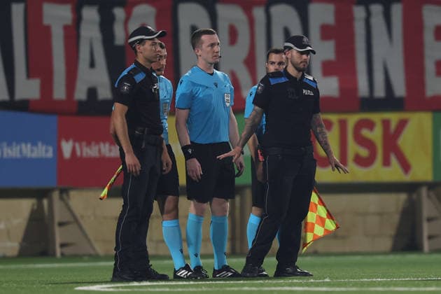 UEFA appointed match referee Jeremy Muller and his assistant referees stand between Malta Police Officers after awarding a late controversial penalty to Runavik during the UEFA Conference League First Qualifying Round, 2nd Leg match between Hamrun Spartans and Runavik at Centenary Stadium, Ta Qali, Malta on 16 July, 2026. Hamrun Spartans v Runavik - UEFA Conference League First Qualifying Round 1st Leg