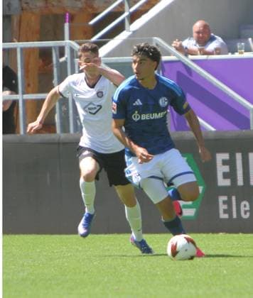 Mertcan Ayhan (Schalke) sichert den Ball gegen Tim Maciejewski (Au, dahintere) ab. Fußball Testspiel FC Erzgebirge Aue - FC Schalke 04 am 19.7.2026 Erzgebirge Aue - Schalke 04 *** Mertcan Ayhan of Schalke clears the ball past Tim Maciejewski of Aue in the background. Soccer friendly match: FC Erzgebirge Aue vs. FC Schalke 04 on July 19, 2026. Erzgebirge Aue vs. Schalke 04