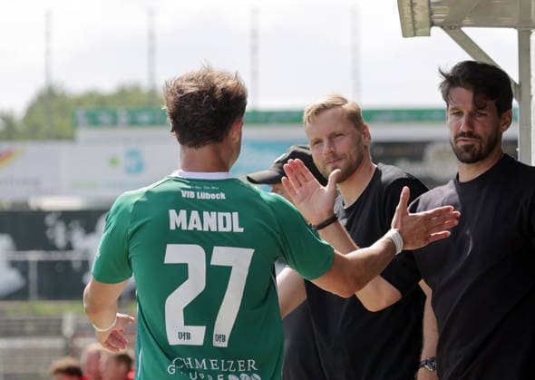 Doppeltorschuetze Felix Mandl (VfB Luebeck klatscht nach seiner Auswechslung mit Sportdirektor Hanno Behrens (VfB Luebeck) und Sportlicher leiter Romain Bregerie (VfB Luebeck) ab )Fussball, Herren, Saison 2026 2027, SHFV-Pokal Achtelfinale, VfB Luebeck gegen Kaltenkirchener TS , 4-1 DFL REGULATIONS PROHIBIT ANY USE OF PHOTOGRAPHS AS IMAGE SEQUENCES AND OR QUASI-VIDEO. *** Felix Mandl, who scored two goals for VfB Lübeck, high-fives sports director Hanno Behrens of VfB Lübeck and sporting director Romain Bregerie of VfB Lübeck after being substituted. Soccer, Men’s, 2026–2027 Season, SHFV Cup Round of 16, VfB Lübeck vs. Kaltenkirchener TS, 4–1. DFL regulations prohibit any use of photographs as image sequences and or quasi-video.