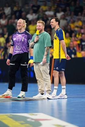 Kevin Gerwin moderiert mit Mikrofon auf dem Spielfeld der SAP Arena in Mannheim, flankiert von Mikael Appelgren ( 1) im lila Torwarttrikot und Patrick Groetzki ( 24; Rhein Neckar Löwen) im gelb-dunkelblauen Trikot. Alle drei lachen und wirken gut gelaunt vor der voll besetzten Tribüne. Patrick Groetzki ( 24; Rhein Neckar Löwen) und Mikael Appelgren ( 1; Team Apfel) mit Moderator Kevin Gerwin *** Kevin Gerwin is hosting the event with a microphone on the ice at the SAP Arena in Mannheim, flanked by Mikael Appelgren 1 in a purple goalie jersey and Patrick Groetzki 24 of the Rhein-Neckar Löwen in a yellow and dark blue jersey. All three are laughing and seem to be in good spirits in front of the packed stands. Patrick Groetzki 24 of the Rhein-Neckar Löwen and Mikael Appelgren 1 of Team Apfel with host Kevin Gerwin Copyright: xspeedshotx xLukasxTrunkx