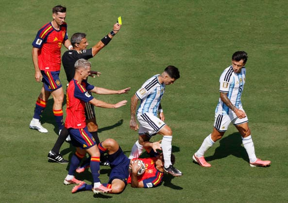 Referee Slavko Vincic books Argentina s Lisandro Martínez (6) for a foul against Spain s Mikel Oyarzabal in the first half of the FIFA World Cup, WM, Weltmeisterschaft, Fussball final match at New York New Jersey Stadium in East Rutherford, New Jersey, on Sunday, June 19, 2026.  NYP20260719934 JOHNxANGELILLO