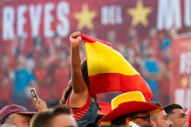 Spanish national team, Nationalteam s victory parade in Madrid - 20 Jul 2026 A young Spanish football fan raises a national flag while sitting on shoulders in front of a Reyes del Mundo (Kings of the World) stage backdrop during the team s World Cup victory parade. An estimated two million people flooded the capital s streets to welcome the squad following their 1-0 win against Argentina in the 2026 FIFA World Cup, WM, Weltmeisterschaft, Fussball final. Madrid Spain Copyright: xMiguelxCandelax xSOPAxImagesx MC_WCWinnerParade1180