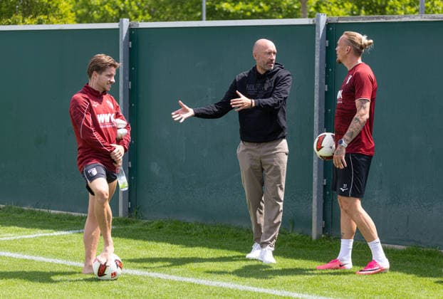 Jacob Friis (Nationaltrainer Finnland, ehemals Co.-Trainer FC Augsburg) machte auf der Durchreise Station beim FC Augsburg, hier im Gespräch mit seinem dänischen Landsmann Mads Pedersen (FC Augsburg 3) und Marius Wolf (FC Augsburg 27, re.); FC Augsburg, Training, *** Jacob Friis, head coach of the Finnish national team and former assistant coach of FC Augsburg, stopped by FC Augsburg while passing through; here he is talking with his Danish compatriot Mads Pedersen (FC Augsburg 3) and Marius Wolf (FC Augsburg 27), re: FC Augsburg, training,