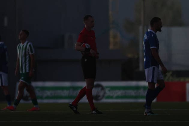 UEFA appointed match referee Marius Hansen Grotta (centre) holds the ball in hand amid a power failure during the UEFA Conference League Second qualifying round, 1st Leg match between Floriana and Drita at Centenary Stadium, Ta Qali, Malta on 21 July, 2026. Floriana v Drita - UEFA Conference League Second Qualifying Round 1st Leg