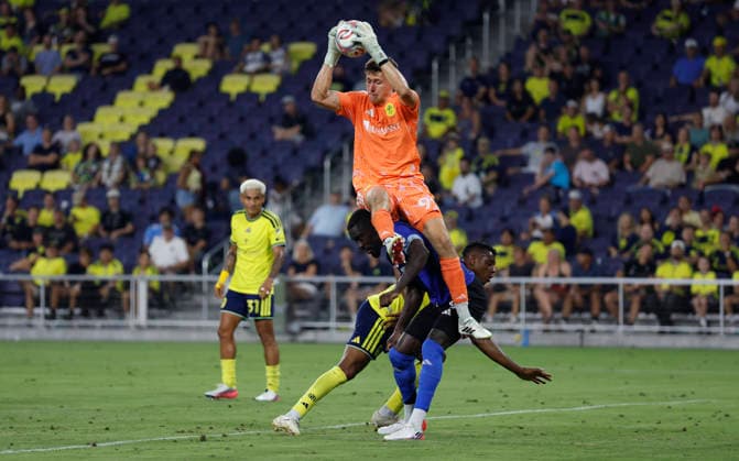 NASHVILLE, TN - JULY 22: Nashville SC goalkeeper Brian Schwake (99) makes a save as he is undercut by CF MontrŽal forward Prince Owusu (9) during a match between Nashville SC and CF MontrŽal, July 22, 2026 at GEODIS Park in Nashville, Tennessee. (Photo by Matthew Maxey Icon Sportswire) SOCCER: JUL 22 MLS, Fussball Herren, USA Nashville SC vs CF Montreal EDITORIAL USE ONLY Icon26072223