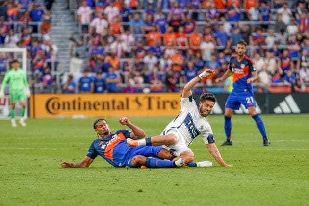 July 22, 2026, Cincinnati, Ohio, USA: FC Cincinnati defense Miles Robinson (12) slide tackles Vancouver Whitecaps forward Brian White (24) from behind for a foul during an MLS, Fussball Herren, USA game at TQL Stadium Soccer 2026:FC Cincinnati V Vancouver Whitecaps  - ZUMAt168 20260722_zsp_t168_014 Copyright: xTrentxPattersonx