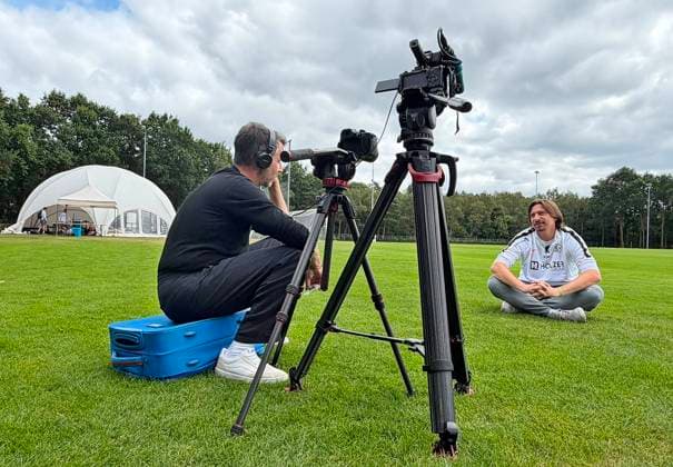 23.07.2026, NED, Fußball, Herren, 1. Bundesliga, Saison 2026 2027, Trainingslager, Rasenplatz, SV Elversberg Vincent Wagner ( Cheftrainer SV Elversberg ) beim Interview mit dem SR Saarländischen Rundfunk (Kommentator Frank Grundhever links), er stellte eine Holzbank weg und setzte sich direkt auf den Rasen, weil das besser findet und es seine Bodenständigkeit und Herzlichkeit besser ausdrückt Stroe Rasenplatz Gelderland Niederlande *** July 23, 2026, NED, Soccer, Men s, 1. Bundesliga, 2026–2027 Season, Training Camp, Grass Field, SV Elversberg’s head coach Vincent Wagner during an interview with SR Saarländischer Rundfunk commentator Frank Grundhever (left); he moved a wooden bench out of the way and sat down directly on the grass because he thinks it’s better that way and it better expresses his down-to-earth nature and warmth. Stroe, grass field, Gelderland, Netherlands Copyright: xNordphotox xSMx