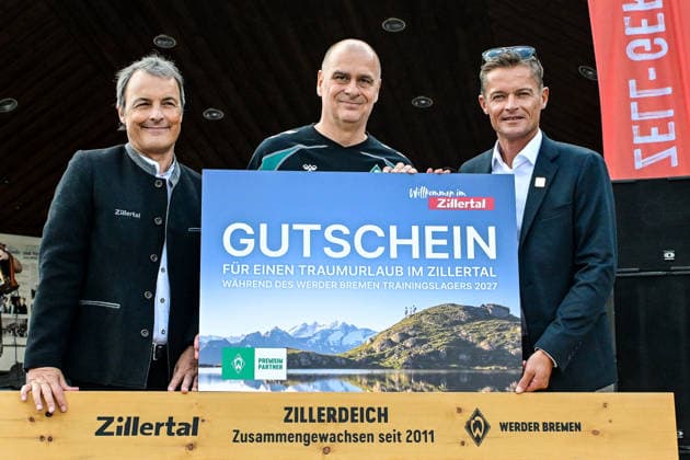 23.07.2026, AUT, Fußball, Herren, 1. Bundesliga, Trainingslager, Saison 2026 2027, Zell am Ziller, 15 Jahre Partnerschaft: SV Werder Bremen & Zillertal Pressegespräch im Rahmen des Trainingslagers 2026 mit anschliesender offiziellen Eröffnung des Kaiserschmarrn Festes, vl, Ronald Felder (Geschäftsführer Zillertal Tourismus GmbH), Klaus Filbry (Vorsitzender der Geschäftsführung und Kaufmännischer Geschäftsführer des SV Werder Bremen), Ferdinand Lechner (Obmann des Tourismusverbands Zell-Gerlos, Zillertal Arena und Verwaltungsratsvorsitzender der Zillertal Tourismus GmbH), Gutschein für eine bedürftige Familie für das Werder Trainingslager 2027 im Zillertal; davor ein vor Werder Bremen an Zell am Ziller gespendete Parkbank Zell am Ziller Musikpavillon Tirol Österreich *** July 23, 2026, Austria, Soccer, Men’s, 1. Bundesliga, Training Camp, 2026–2027 Season, Zell am Ziller, 15 Years of Partnership Between SV Werder Bremen and Zillertal: Press Conference as part of the 2026 training camp, followed by the official opening of the Kaiserschmarrn Festival; from left: Ronald Felder, Managing Director of Zillertal Tourismus GmbH, Klaus Filbry, Chairman of the Executive Board and Commercial Director of SV Werder Bremen, Ferdinand Lechner, Chairman of the Zell-Gerlos Tourism Association, Zillertal Arena and Chairman of the Board of Directors of Zillertal Tourismus GmbH; a voucher for a family in need to attend the 2027 Werder training camp in the Zillertal, in front of a park bench donated by Werder Bremen to Zell am Ziller; Zell am Ziller Music Pavilion, Tyrol, Austria Copyright: xNordphotox xHafnerx
