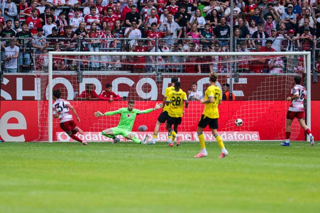 25.07.2026, Fussball, Testspiel Fortuna Düsseldorf - Borussia Dortmund. Anas Slimani (Fortuna Düsseldorf) trifft zum 2:1 gegen Torwart Patrick Drewes (Borussia Dortmund). Düsseldorf Trainingsgelände des BVB NRW Deutschland xRHR-FOTO DEx *** July 25, 2026, Soccer, Friendly Match: Fortuna Düsseldorf vs. Borussia Dortmund; Anas Slimani scores for Fortuna Düsseldorf, beating goalkeeper Patrick Drewes; Borussia Dortmund; Düsseldorf; BVB training facility; NRW, Germany; xRHR; PHOTO: DEx Copyright: DennisxEwert RHR-FOTOx RHR-FOTO DE
