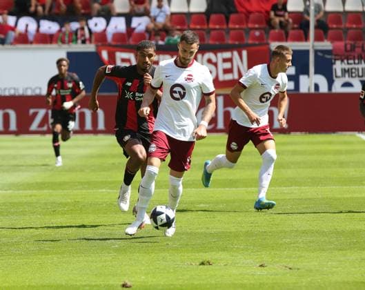25.07.2026 xmgoodx Offenbach am Main, Plutos Stadion am Bieberer Berg - Jubiläumsspiel Kickers Offenbach (OFC) - Bayer 04 Leverkusen. Loic Bade (5, Leverkusen) gegen Maximilian Wolfram (8, OFC) *** July 25, 2026 xmgoodx Offenbach am Main, Pluto Stadium at Bieberer Berg Anniversary Match: Kickers Offenbach vs. OFC Bayer 04 Leverkusen Loic Bade 5 (Leverkusen) vs. Maximilian Wolfram 8 (OFC)