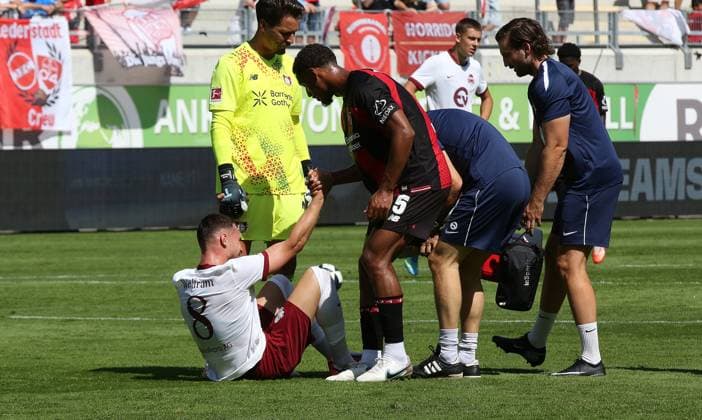 25.07.2026 xmgoodx Offenbach am Main, Plutos Stadion am Bieberer Berg - Jubiläumsspiel Kickers Offenbach (OFC) - Bayer 04 Leverkusen. Loic Bade (Leverkusen) kümmert sich um den verletzten Maximilian Wolfram (8, OFC) *** July 25, 2026 xmgoodx Offenbach am Main, Pluto Stadium at Bieberer Berg Anniversary Match: Kickers Offenbach vs. OFC Bayer 04 Leverkusen Loic Bade (Leverkusen) tends to the injured Maximilian Wolfram (8), OFC