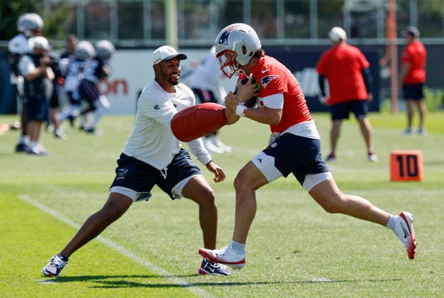 FOXBOROUGH, MA - JULY 26: Behren Morton 15 of the New England Patriots covers ups as New England Patriots quarterbacks coach Ashton Grant tries to knock the ball loose during New England Patriots Training Camp on July 26, 2026, at Gillette Stadium in Foxborough, Massachusetts. (Photo by Fred Kfoury III Icon Sportswire) NFL, American Football Herren, USA JUL 26 Patriots Training Camp EDITORIAL USE ONLY Icon482260726022