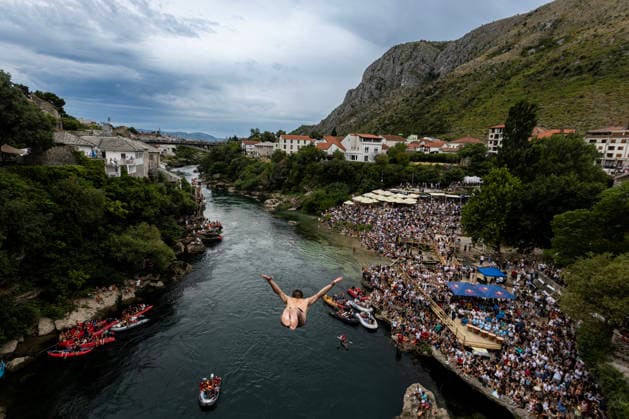Mostar Old Bridge Diving Competition A participant dives from historical Old Bridge , also known as Mostar Bridge during the traditional diving competition event, 460th Traditional Mostar Old Bridge Diving Competition, in Mostar, Bosnia and Herzegovina on July 26, 2026. Each year, thousands of spectators watch the event across the Old Bridge that crosses Neretva river.  DenisxKapetanovic PIXSELL