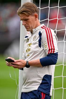 27.07.2026, Fussball Bundesliga 2026 2027, Trainingslager FC Bayern München in Rottach-Egern am Tegernsee (Bayern). Sportdirektor Christoph Freund (Bayern München) lehnt mit Handy am Pfosten *** July 27, 2026, 2026–2027 Bundesliga, FC Bayern Munich training camp in Rottach Egern on Lake Tegernsee; Bayern sporting director Christoph Freund; Bayern Munich player leans against the goalpost with his cell phone