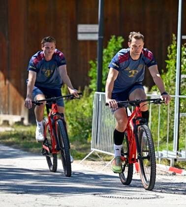 28.07.2026, Fussball Bundesliga 2026 2027, Trainingslager FC Bayern München in Rottach-Egern am Tegernsee (Bayern). v.l. Torwart Jonas Urbig (FC Bayern München) und Torwart Manuel Neuer (FC Bayern München) auf dem Fahrrad *** July 28, 2026, 2026–2027 Bundesliga, FC Bayern Munich training camp in Rottach-Egern on Lake Tegernsee, Bavaria: (from left) Goalkeeper Jonas Urbig of FC Bayern Munich and goalkeeper Manuel Neuer of FC Bayern Munich on bicycles