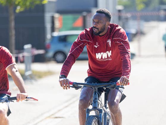 Chrislain Matsima (FC Augsburg 5) mit dem Fahrrad auf dem Weg zum Trainingsplatz; FC Augsburg, Training, *** Chrislain Matsima, FC Augsburg 5, riding his bike on the way to the FC Augsburg training field, training,