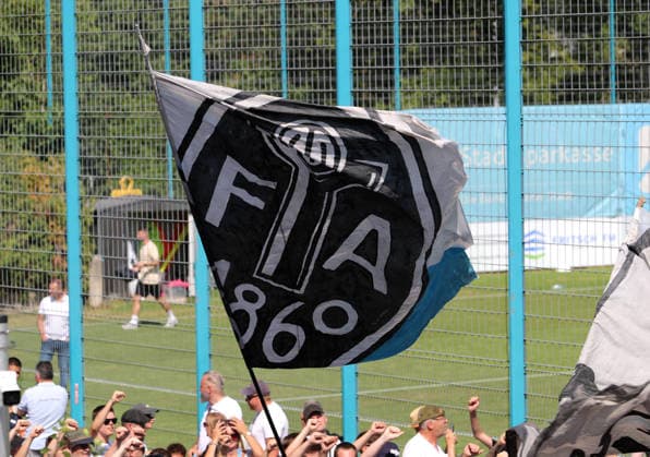 Fussball, Herren, Regionalliga Bayern, Saison 2026 2027, TSV 1860 München, Training Fanmarsch,Auflauf der Ultras, EV Anhänger am Trainingsgelände bei Training des TSV 1860 München, Gesänge, Anfeuern, Fahne mit dem Logo der Fussballabteilung *** Soccer, Men s, Bavarian Regional League, 2026–2027 Season, TSV 1860 Munich, fan march to practice, Ultras gathering, EV supporters at the training facility during TSV 1860 Munich practice, chants, cheering, flag with the soccer division’s logo