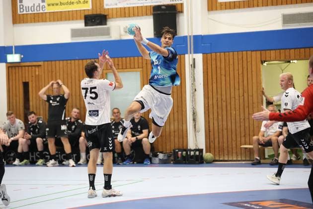 Julian Köster springt hoch in die Luft und zieht zum Wurf ab, während Tjorben Heckel ( 75; HSG Eider Harde) mit erhobenen Armen versucht, den Abschluss zu blocken. Im Hintergrund verfolgen Ersatzspieler und Jesse Kock ( 21; HSG Eider Harde) die Szene von der Bank. Julian Köster im Sprungwurf gegen HSG Eider Harde in Hohn *** Julian Köster jumps high into the air and takes a shot, while Tjorben Heckel (75, HSG Eider Harde), with his arms raised, tries to block the shot. In the background, substitutes and Jesse Kock (21, HSG Eider Harde) watch the action from the bench. Julian Köster takes a jump shot against HSG Eider Harde in Hohn Copyright: xspeedshotx
