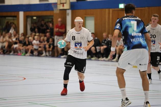 Jonah Schatz ( 8; HSG Eider Harde) trägt den Ball und sucht eine Anspielstation, während ein Spieler von THW Kiel mit der Rückennummer 7 (Köster) den Weg versperrt. Im Hintergrund sind zahlreiche Zuschauer in der Werner-Kuhrt-Halle in Hohn zu sehen. Jonah Schatz ( 8; HSG Eider Harde) mit Ball im Spielaufbau *** Jonah Schatz (No. 8, HSG Eider Harde) is carrying the ball and looking for a teammate to pass to, while a THW Kiel player, Köster (No. 7), blocks his path. In the background, numerous spectators can be seen in the Werner Kuhrt Halle in Hohn. Jonah Schatz (No. 8, HSG Eider Harde) with the ball as the team builds up its offense. Copyright: xspeedshotx