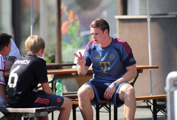 Fussball, Herren, Bundesliga, Saison 2026 2027, FC Rottach-Egern - FC Bayern München, Testspiel, Trainingslager, Rottach-Egern Jonas Urbig (FC Bayern München) spricht mit einem jungen Fan *** Soccer, Men s, Bundesliga, 2026–2027 Season, FC Rottach Egern vs. FC Bayern Munich, Friendly Match, Training Camp, Rottach Egern: Jonas Urbig of FC Bayern Munich talks with a young fan