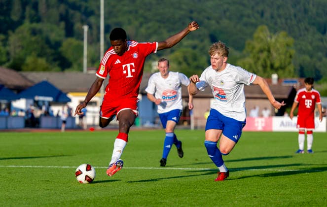 30.07.2026, Fussball Bundesliga 2026 2027, Trainingslager FC Bayern München in Rottach-Egern am Tegernsee (Bayern). Testspiel FC Rottach Egern - FC Bayern München, Bastian Assomo (li,Bayern München) im Zweikampf *** July 30, 2026, 2026–2027 Bundesliga, FC Bayern Munich training camp in Rottach Egern on Lake Tegernsee, Bavaria; friendly match between FC Rottach Egern and FC Bayern Munich; Bastian Assomo (left); FC Bayern Munich in a tackle