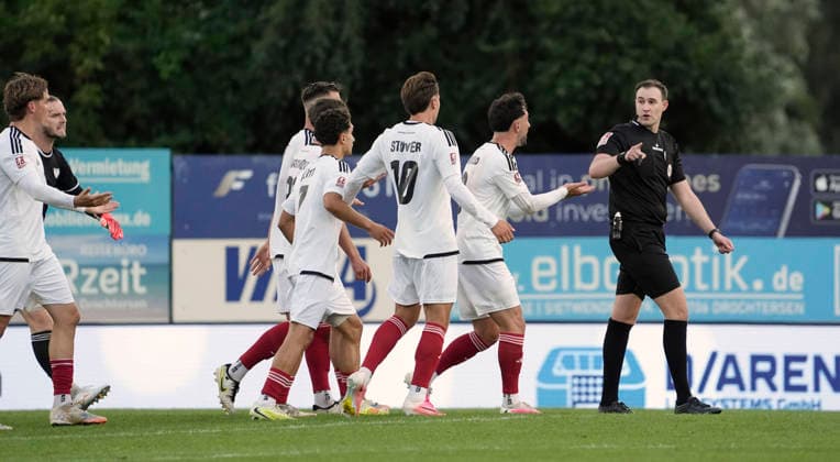 Foto : JUbel bei Drochtersen nach dem verrückten Torschuss ( Bogenlampe ) von Christopher SCHEPP , hier protestieren die Phönix Spieler Fabio Oliveira MAIOLO und Jonathan STÖVER ( 10 ) und Benjamin LUIS ( 24 ) gegen Schiri Dominik Kopmann Fussball Regionalliga Nord, 1. Spieltag am Fr. 31.07.2026 SV Drochtersen - Phönix Lübeck 2 - 1 *** Photo: Jubilation in Drochtersen after Christopher SCHEPP’s crazy arcing shot; here, Phoenix players Fabio Oliveira MAIOLO and Jonathan STÖVER (10) and Benjamin LUIS (24) are protesting against referee Dominik Kopmann. Soccer Regionalliga Nord, Matchday 1 on Fri, July 31, 2026: SV Drochtersen vs. Phönix Lübeck, 2–1